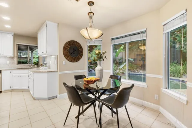 a dining room filled chandelier and wooden floor