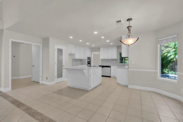 a view of kitchen with white cabinets and wooden floor