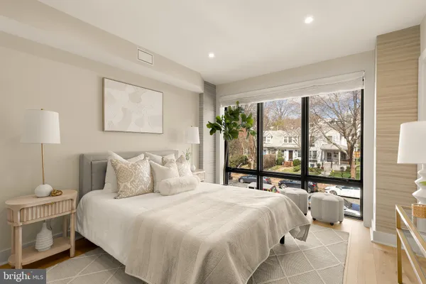 a bedroom with a large bed and a potted plant