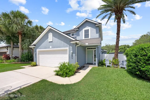 a front view of a house with a garden and plants