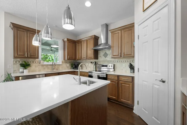 a kitchen with a sink stove and wooden floor
