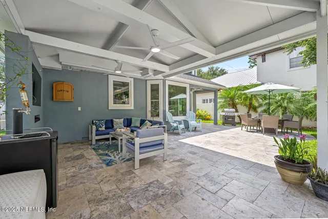 a living room with patio furniture and a large window