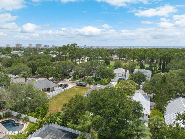 an aerial view of residential houses with outdoor space and trees