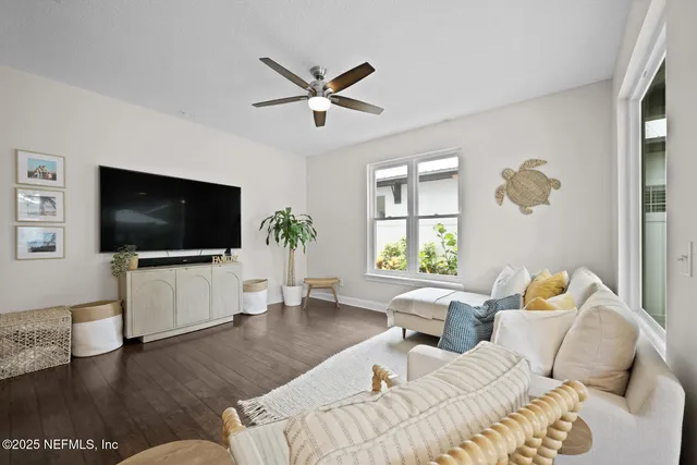 a living room with furniture and a large window with wooden floor