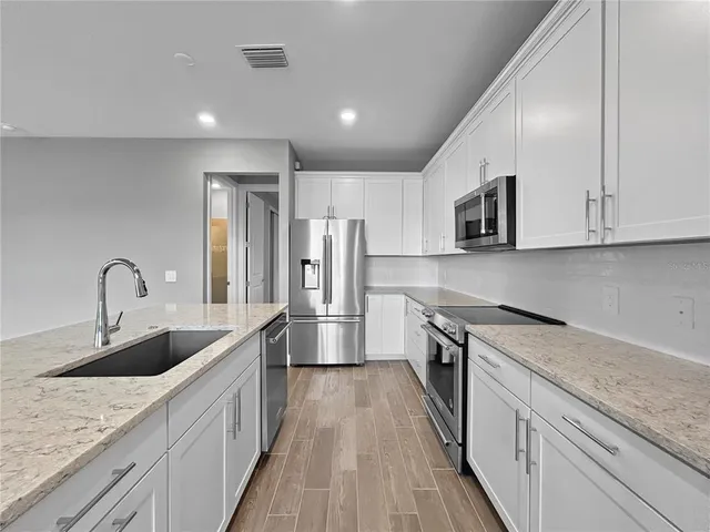 a kitchen with a refrigerator stove and cabinets
