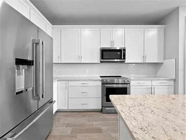 a kitchen with stainless steel appliances granite countertop a sink and a window