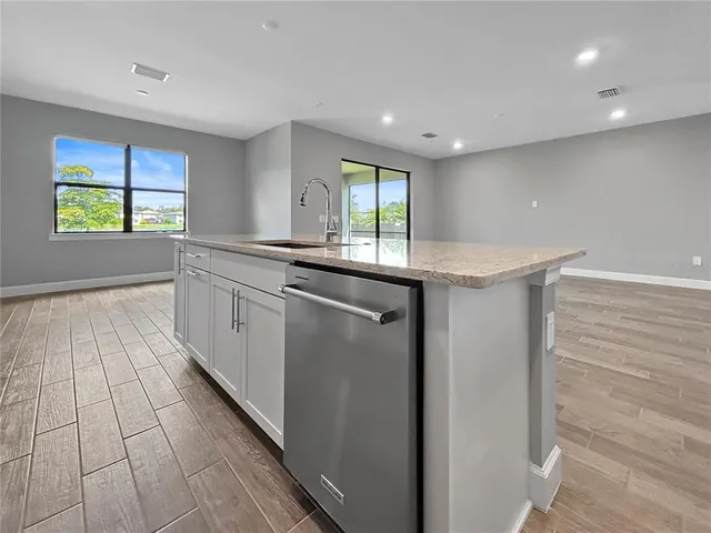 a large kitchen with stainless steel appliances granite countertop a lot of counter space