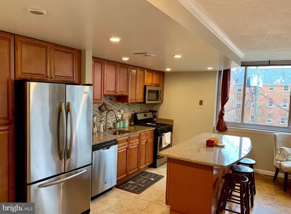 a kitchen with stainless steel appliances granite countertop a refrigerator stove microwave and sink