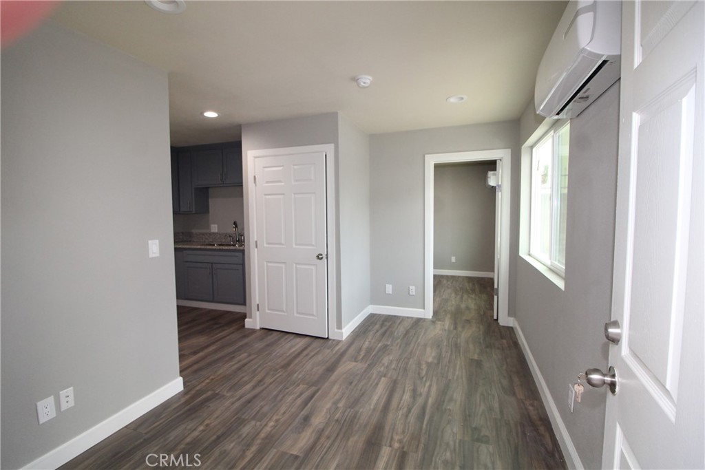 4986 Southern Avenue, Unit E South Gate, CA 90280 - Photo 4 of 9 wooden floor in an empty room with a kitchen