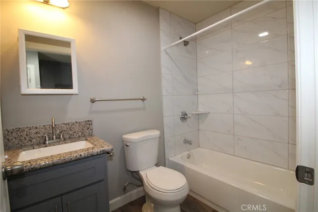 a bathroom with a granite countertop toilet a sink and bathtub