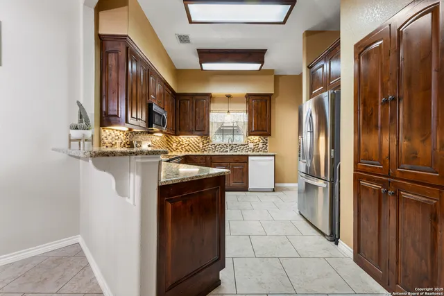 a kitchen with stainless steel appliances granite countertop a stove and a microwave