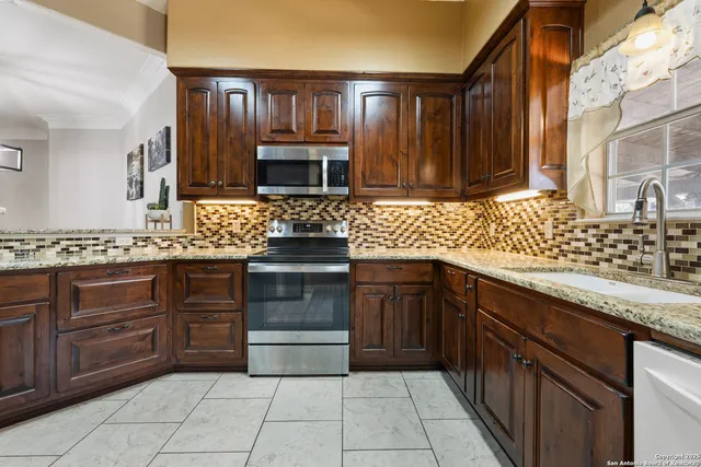 a kitchen with stainless steel appliances granite countertop a refrigerator and a sink