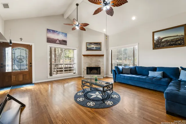 a living room with furniture a flat screen tv and a fireplace