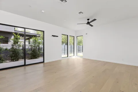 an empty room with sliding glass door and windows