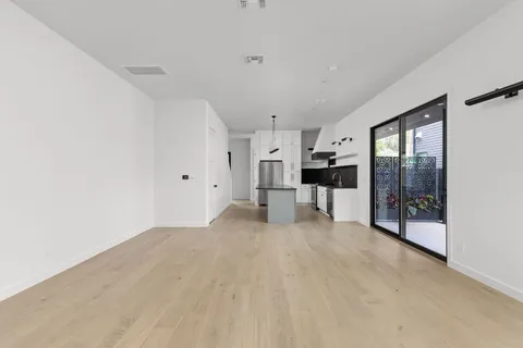 a view of a living room hardwood floor and a kitchen