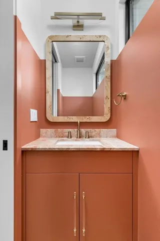 a bathroom with a granite countertop sink and a mirror