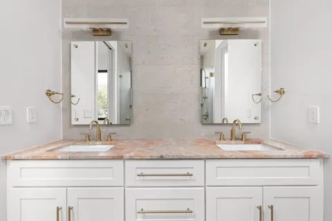 a bathroom with double vanity sinks and a mirror
