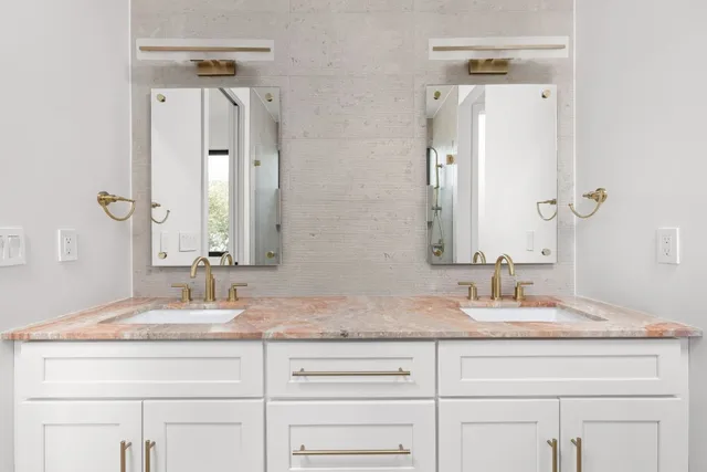 a bathroom with double vanity sinks and a mirror