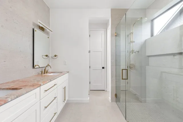 a spacious bathroom with a granite countertop sink mirror and shower