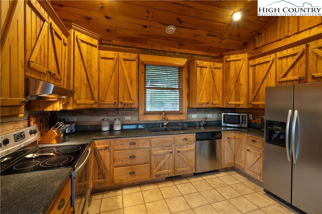 546 Big Sky Road Ferguson, NC 28624 - Photo 8 of 23 a kitchen with granite countertop a sink stainless steel appliances and cabinets