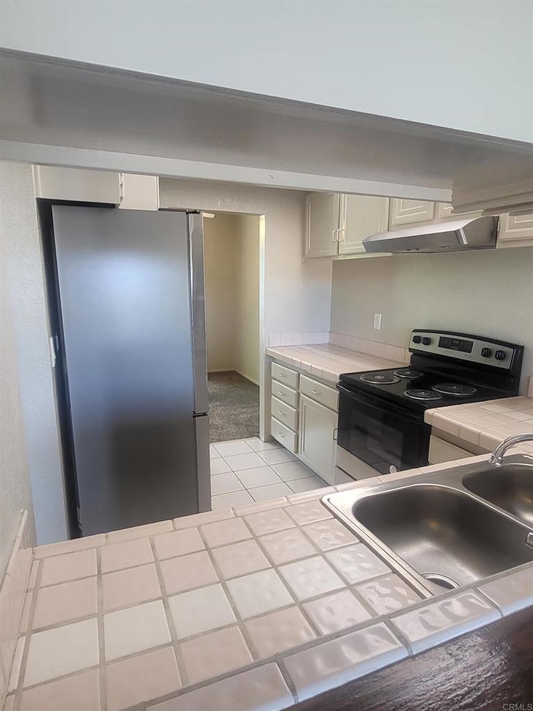 2319 Caringa Way, Unit 56 Carlsbad, CA 92009 - Photo 12 of 24 a kitchen with a sink and a refrigerator