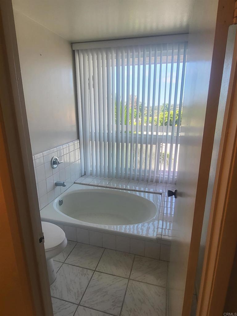 2319 Caringa Way, Unit 56 Carlsbad, CA 92009 - Photo 17 of 24 a bath tub sitting in a bathroom next to a window