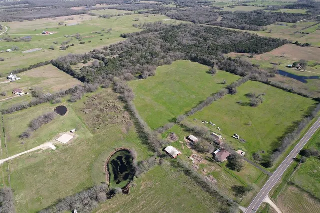 an aerial view of a houses with outdoor space and trees