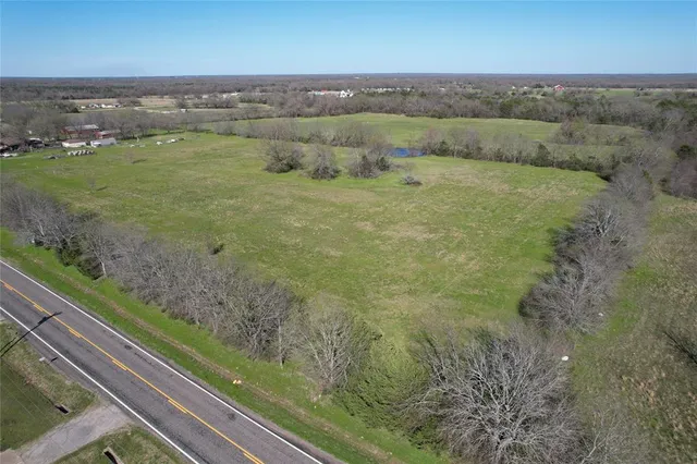 a view of a field with an ocean and mountains in the back