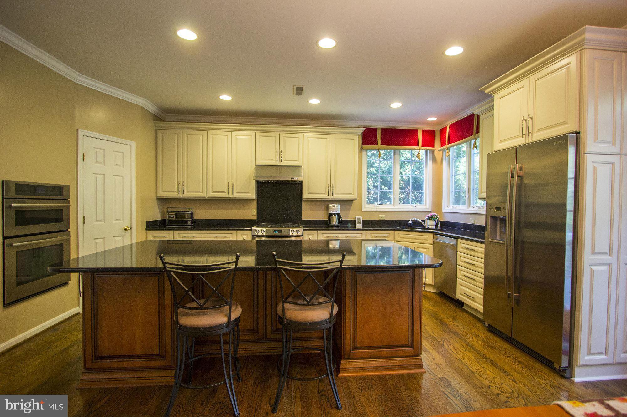 1827 Beulah Road Vienna, VA 22182 - Photo 12 of 30 a kitchen with stainless steel appliances granite countertop a table chairs sink refrigerator and microwave