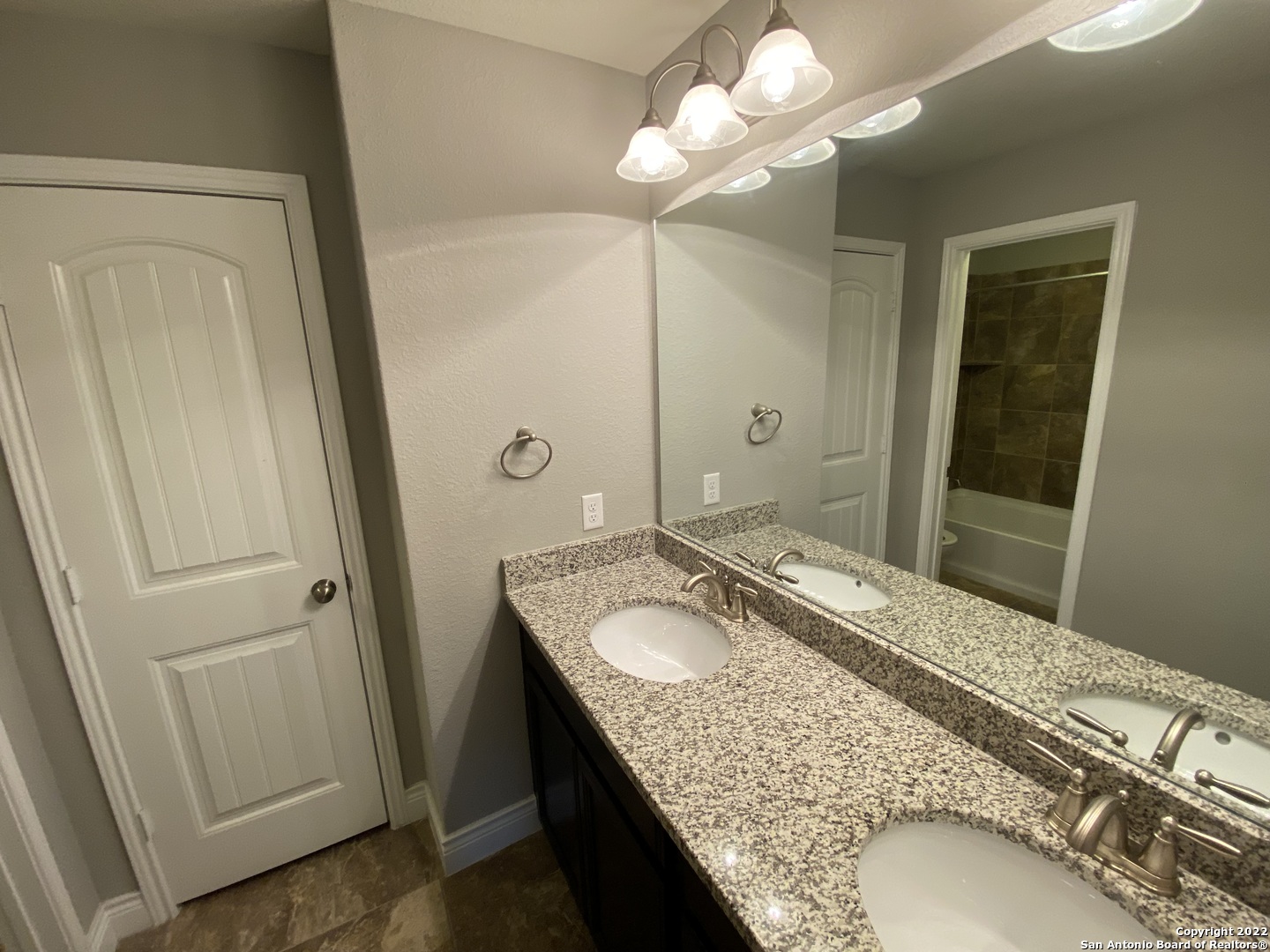 27447 Rio Circle Boerne, TX 78015 - Photo 14 of 18 a bathroom with a granite countertop sink a mirror and a shower