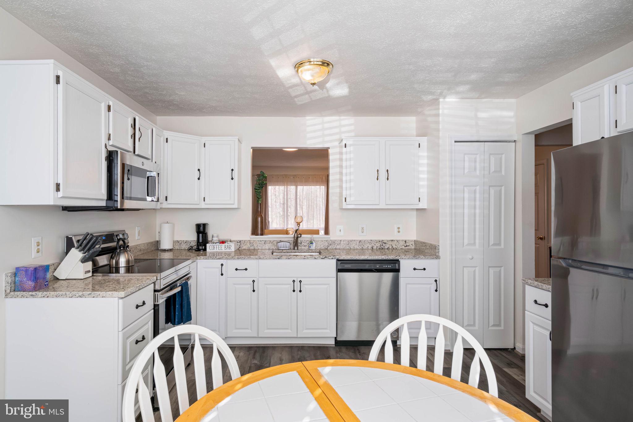 407 Kings Crest Drive Stafford, VA 22554 - Photo 9 of 42 a kitchen with stainless steel appliances granite countertop a sink stove refrigerator and cabinets