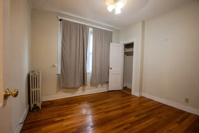 an empty room with wooden floor and a window