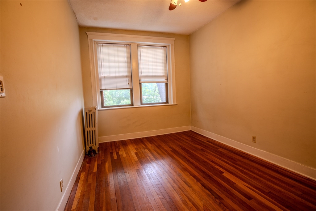 153 Strathmore Road, Unit 4 Boston, MA 02135 - Photo 5 of 9 an empty room with wooden floor and windows