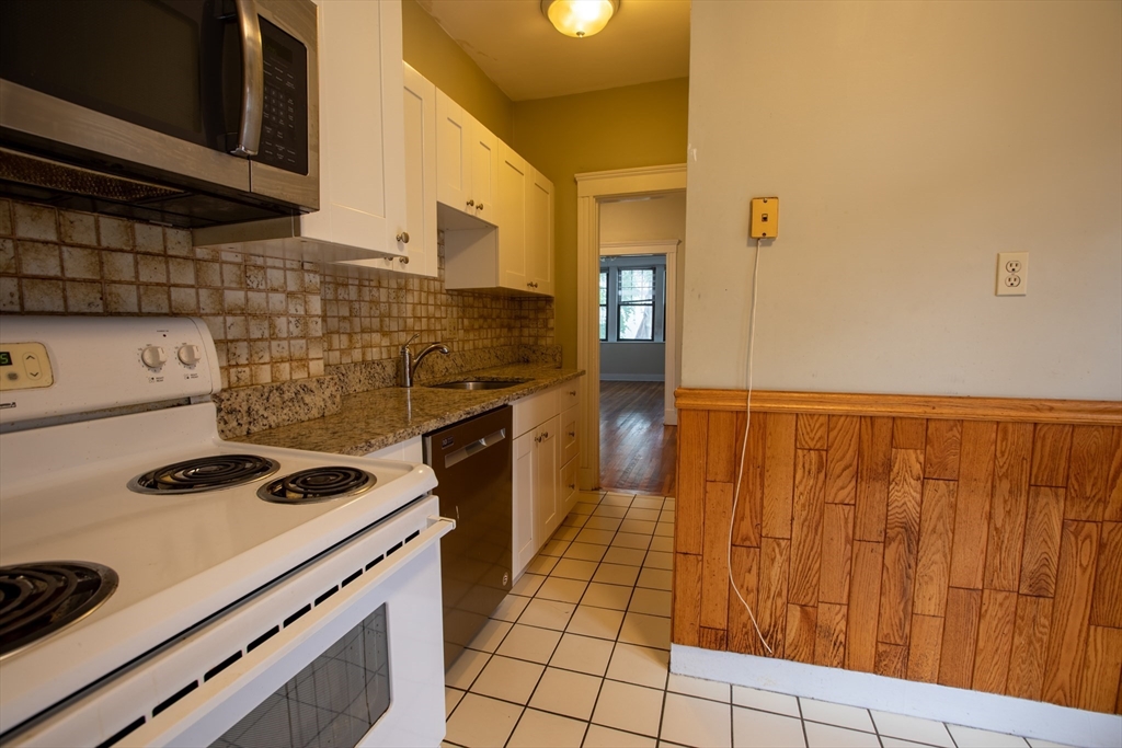 153 Strathmore Road, Unit 4 Boston, MA 02135 - Photo 8 of 9 a kitchen with a cabinets and a stove top oven