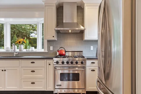 a kitchen with granite countertop white cabinets and white appliances