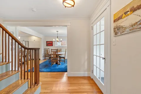a view of a hallway with wooden floor and dining room