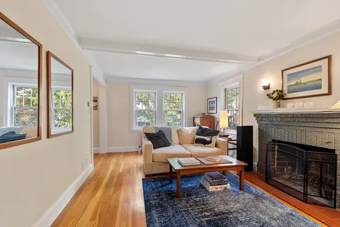a living room with furniture a large window and a fireplace