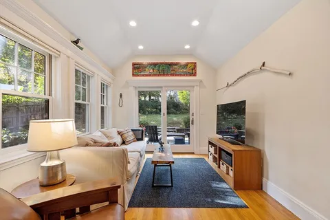 a living room with furniture a flat screen tv and a large window