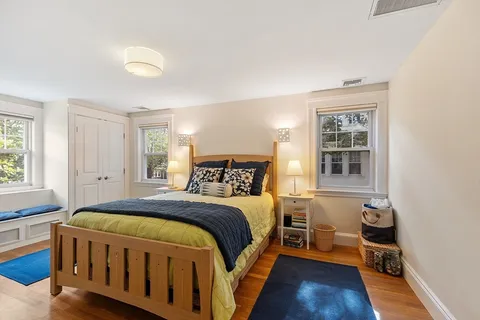 a spacious bedroom with a bed and wooden floor