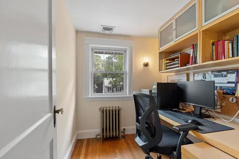 a view of a workspace with furniture and a window