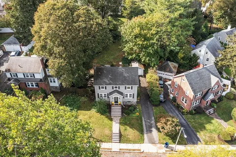 an aerial view of a house with garden space and street view