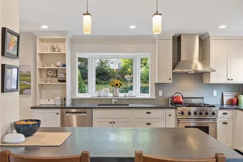 a kitchen with stainless steel appliances granite countertop a sink a stove and a refrigerator