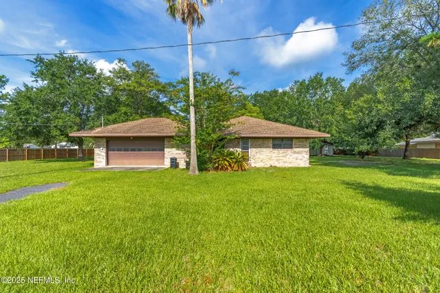 a view of a house with a backyard and a garden