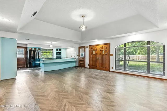 a view of an empty room with a fireplace and a large window