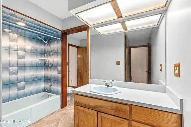 a bathroom with a tub sink and mirror