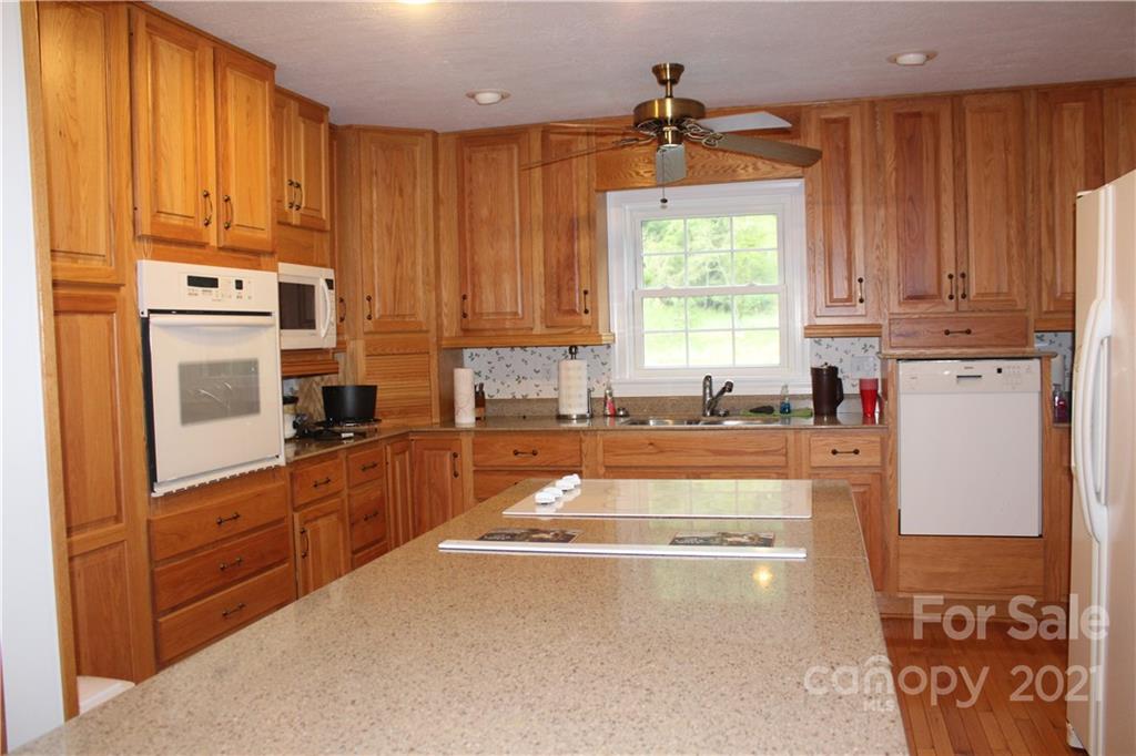 718 Bald Mountain Road Burnsville, NC 28714 - Photo 2 of 20 a kitchen with stainless steel appliances a stove sink and cabinets