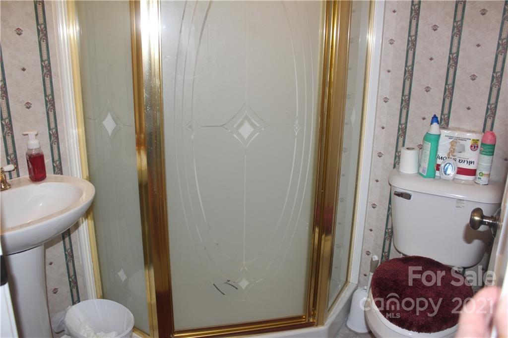 718 Bald Mountain Road Burnsville, NC 28714 - Photo 7 of 20 a bathroom with a sink a toilet and a mirror