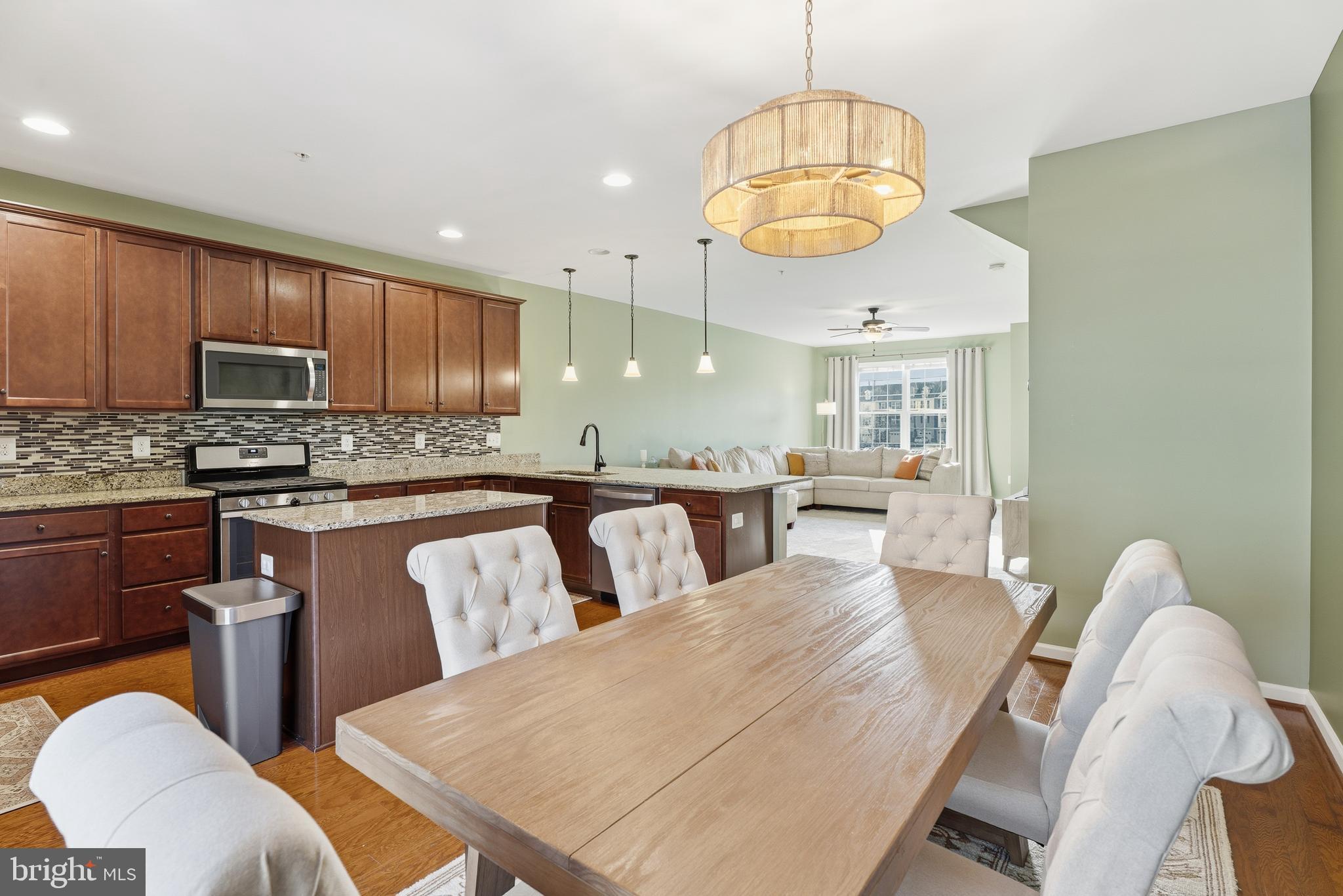 980 Winter Run Road Middle River, MD 21220 - Photo 17 of 43 a kitchen with stainless steel appliances kitchen island granite countertop a stove a kitchen island a dining table and chairs