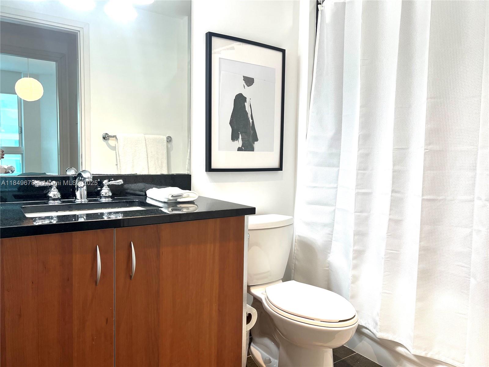 300 South Biscayne Boulevard, Unit T1602 Miami, FL 33131 - Photo 15 of 20 a bathroom with a toilet a sink and a mirror