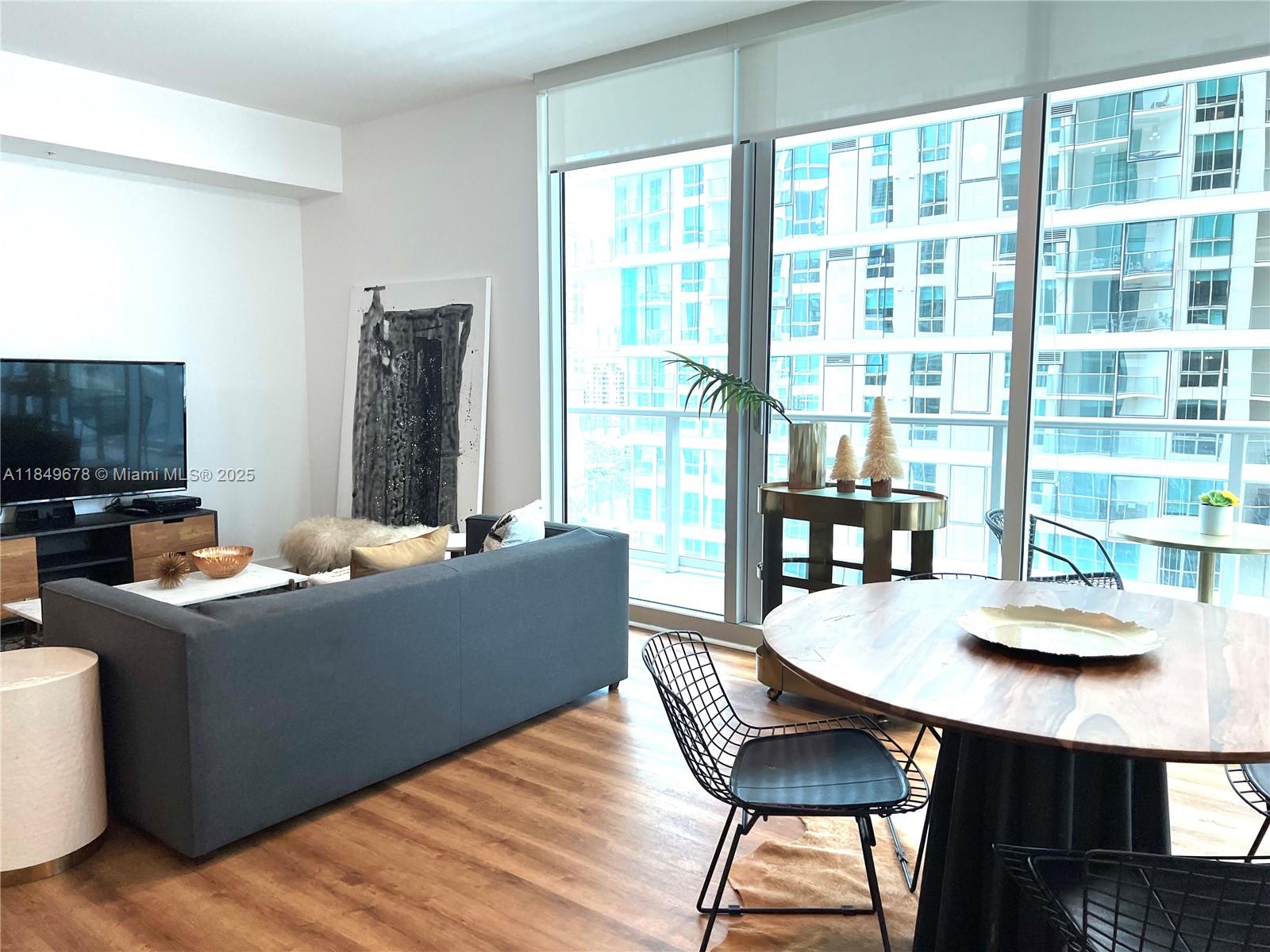 300 South Biscayne Boulevard, Unit T1602 Miami, FL 33131 - Photo 9 of 20 a living room with furniture and a flat screen tv